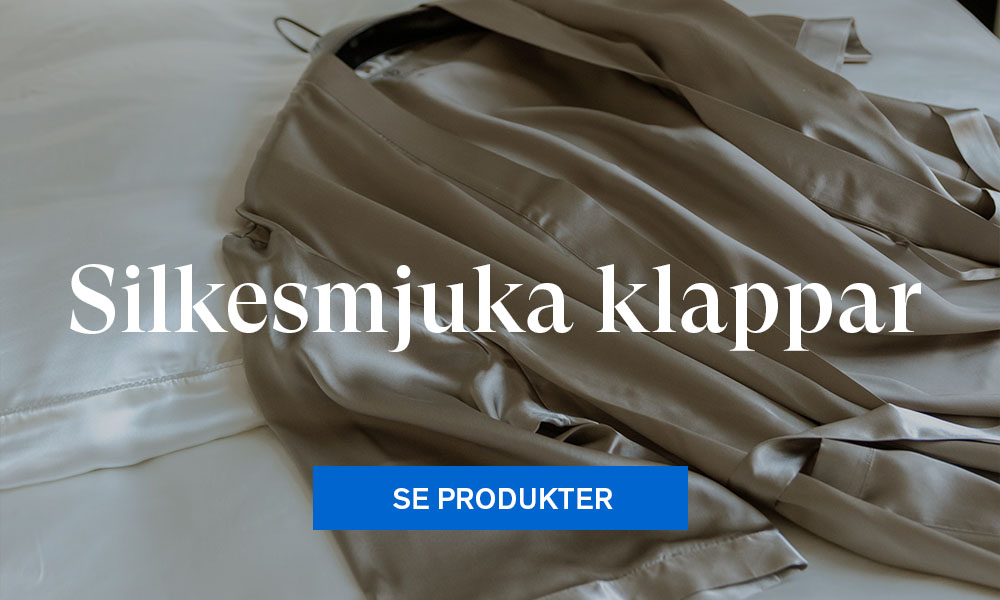 Morgonrock i silke ligger på en säng.